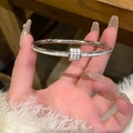 Detail of silver stainless steel bangle with micro-pave zircon cylinder charm - Titanium Circle / Silver