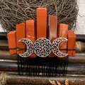 Macro shot of Red Jasper crystals and Triple Moon filigree on a handmade metal hair comb - Red Stone Black Wire Silver Moon