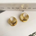 Vista macro de pendientes geométricos dorados con diseño de capas y textura de abanico - Dorado