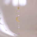 Detail of amethyst suncatcher with golden sun and moon pendants on beige wall - Style 5-Moon Sun Combo Amethyst Pendant