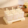 Molde para helados amarillo de 9 rejillas sobre mesa de madera clara con mangos - Amarillo Ganso