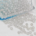 Macro shot of 6mm-8mm round crackle glass beads spilling onto a white background - 8mm / White