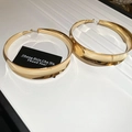 Detailansicht großer goldener Creolen mit Spiegelglanz auf einer Display-Schale - Gold