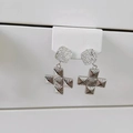 Dettaglio di orecchini a croce in argento con borchie quadrate e centro con trama a spirale - Orecchini a croce / Orecchini d'argento