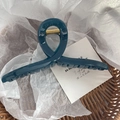 Détail d'une grande pince à cheveux bleu foncé dans un panier avec ressort doré - Bleu