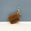 Detailed view of a brown plush coin purse with gold lobster clasp and tassel decoration - Brown