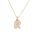 Detail of letter R pendant featuring micro-pave cubic zirconia and gold box chain - Letter R
