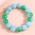 Macro detail of natural green gradient jade beads on a minimalist pink background - Light Green Gradient