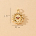 Detail of a 2.8x2cm sunburst evil eye pendant with red gem and clear crystals - Gold Sunburst Eye with Red Gem Pendant (L)