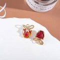 Macro detail of golden bow pendants with red and orange gradient heart crystals - Orange Red Gradient/Dark Red