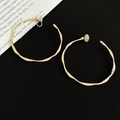 Detail of gold twisted hoop clip-on earrings with textured finish and soft pads - Clip-on Style / 6cm / Gold