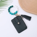 Detail of dark green leather card holder with silicone bead wristlet and gold hardware - Dark Green