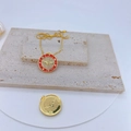 Macro shot of gold-plated evil eye pendant with red enamel, CZ heart and wing details - Red Enamel Wing Heart