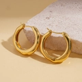 Détail de boucles d'oreilles dorées en forme de C avec texture ondulée sur pierre - Créole Plaqué Or 18K / Or