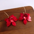 Dettaglio di grandi orecchini a fiore in resina rossa con ganci dorati su legno - Perno per orecchini in argento - Rosso
