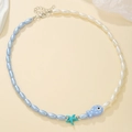 Close-up of beaded necklace with blue starfish, fish pendants and adjustable metal clasp - D1665-1 (Blue White Two-tone Starfish Fish)