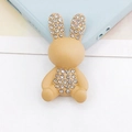 Vista macro di un accessorio per telefono a forma di coniglio beige con strass lucidi - Coniglio Cachi