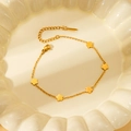 Detail of gold flower charm bracelet with lobster clasp on white ceramic plate - Gold Flower Bracelet