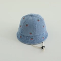 Dettaglio di cappello pescatore in denim azzurro con ricamo ciliegia e cinturino regolabile - 48-50cm (1-2 anni) / Blu