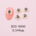 Macro detail of 9.5x8mm bow nail charms with black heart crystal and gold alloy base - Gold Bow + Black Heart Stone (9980)