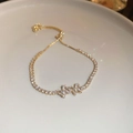 Detail of adjustable gold bracelet with shimmering cubic zirconia star flower charms - Gold Zirconia Butterfly Adjustable Bracelet