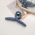 Detail of matte blue shark hair claw clip in a minimalist lifestyle setting with mirror - Cross / Navy Blue