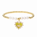 Close-up of beaded pearl bracelet with heart devil eye pendant in gold and green - Yellow