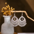 Detailed shot of ethnic silver earrings with hollow patterns and ball tassels on wood - Silver Geometric Hollow Ball(E2875-21)