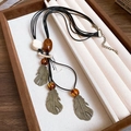 Collier rétro bohème à plumes en bronze avec perles d'ambre et cordon noir tressé - 21# Collier-Noir-Café-Bronze (Trois Plumes)