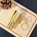 Mini tumbler keychain in golden finish with metal hook on a decorative wooden tray - Dazzling Gold / Gold Buckle