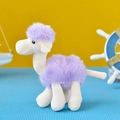 Close-up detail of a soft purple and white plush camel toy pendant for bags and keys - Purple
