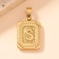Macro detail of a golden rectangular pendant featuring a textured letter S design - Letter S
