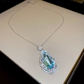 Vue macro du collier avec pierre bleue en poire et halo de diamants sur chaîne - Collier Goutte d'Eau Fleur Bleue