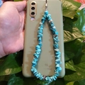 Dettaglio del cinturino per telefono in pietre turchesi su cover verde tenuta in mano - Stile Turchese Frantumata (款四)
