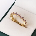 Golden wavy ring with purple cubic zirconia stones showcased in a dark green jewelry box - Adjustable Open / Purple Zirconia (Gold)