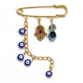Golden Hamsa hand and blue evil eye charms dangling from a safety pin brooch - Pin with Blue Eye Chain, Red Eye Hamsa, and Crystal