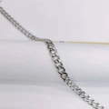 Macro detail of silver stainless steel Cuban link chain with a high-polished metallic finish - 7mm Thick 50cm Long