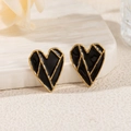 Dettaglio di orecchini a cuore in oro 18k con smalto nero su base in pietra - Cuore Geometrico Nero
