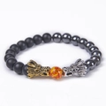 Detailed shot of beaded dragon bracelet featuring gold and silver charms with tiger eye stone - Matte Stone & Hematite