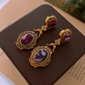 Detaillierte Makroansicht von Vintage-Goldohrringen mit lila Schmucksteinen - Goldener ovaler lila Steinstil (8#)
