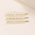 Close-up of golden hair clips with colorful iridescent bubble pearls on beige background - Gold Set