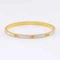 Gros plan du bracelet en acier titane doré avec nacre blanche et cristaux scintillants - Or