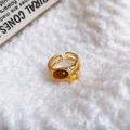Détail macro d'une bague plaquée or avec œil de tigre et zircone sur fourrure blanche - Style Œil de Tigre Plaqué Or / Brun doré