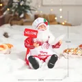 Chef Santa Claus figurine in red checkered outfit with Merry Christmas apron and welcome sign - Sitting Posture