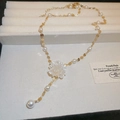 Detail van de goudkleurige ketting met witte bloemenhanger van hars en imitatieparels - Witte Bloem Parelketting