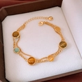 Detalle de la pulsera de plata S925 bañada en oro de 18k con piedras de ojo de gato - Estilo de Doble Capa de Oro con Piedra de Ojo de Gato