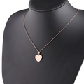 Detalle de collar con colgante de corazón oro rosa en un busto de maniquí negro - Oro rosa