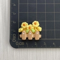 Detail of yellow resin flower fence figurine on a measurement grid for DIY crafts - Three Yellow Flowers Fence