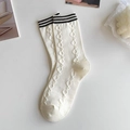 Close-up of cream beige mid-calf socks with black stripes and knit texture patterns - Black Striped Cuff
