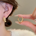 Close-up of golden twisted hoop earrings showing refined texture and style on model - 35# Ear Buckle - Gold Twisted Texture